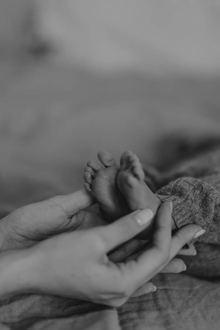 Close up on newborn feet. Mum is holding newborn feet. Basingstoke newborn photo shoot. Basingstoke newborn photo shoot. Ewa Jones Photography