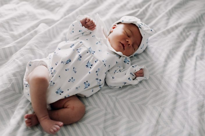 little baby girl is laying on bed and sleeping. newborn photo session in Hampshire. natural photography. Ewa Jones Photography