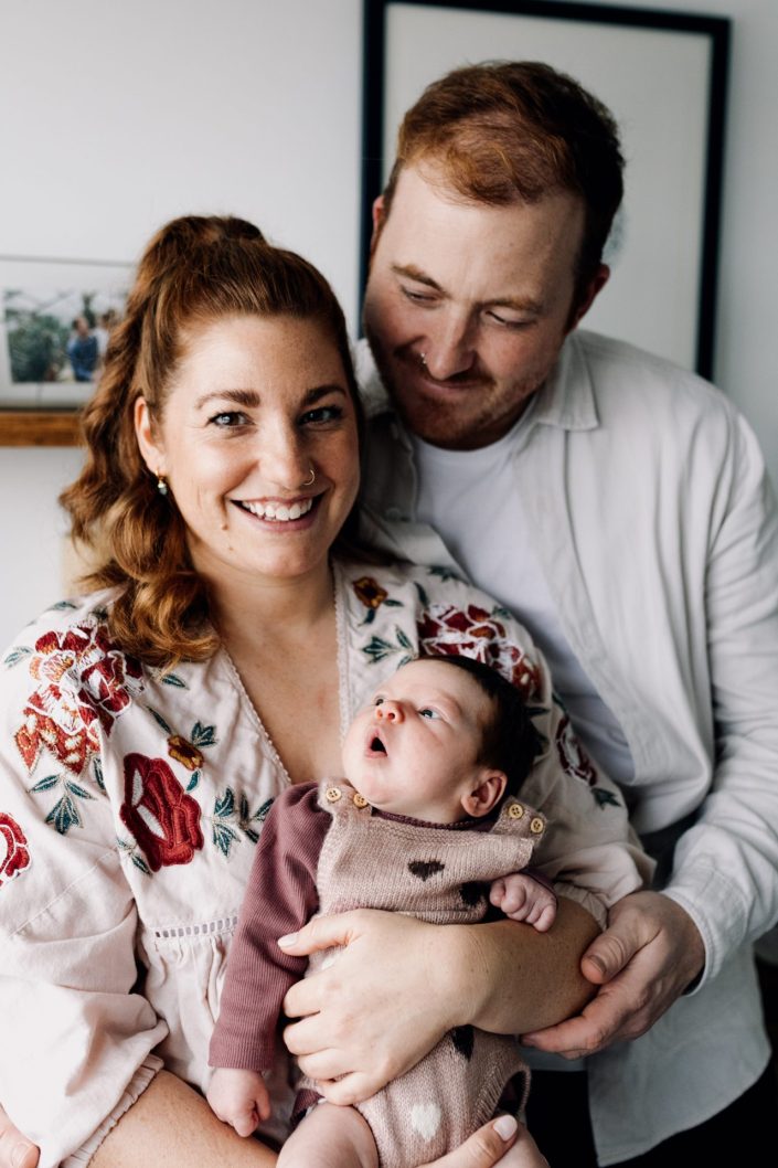 mum and dad are cuddling their newborn baby. lovely photo session at home. Hampshire photography. Ewa Jones Photography