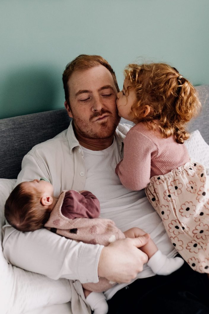 dad is cuddling his two daughters. what to wear for a family session. Hampshire newborn photo shoot. Ewa Jones Photography