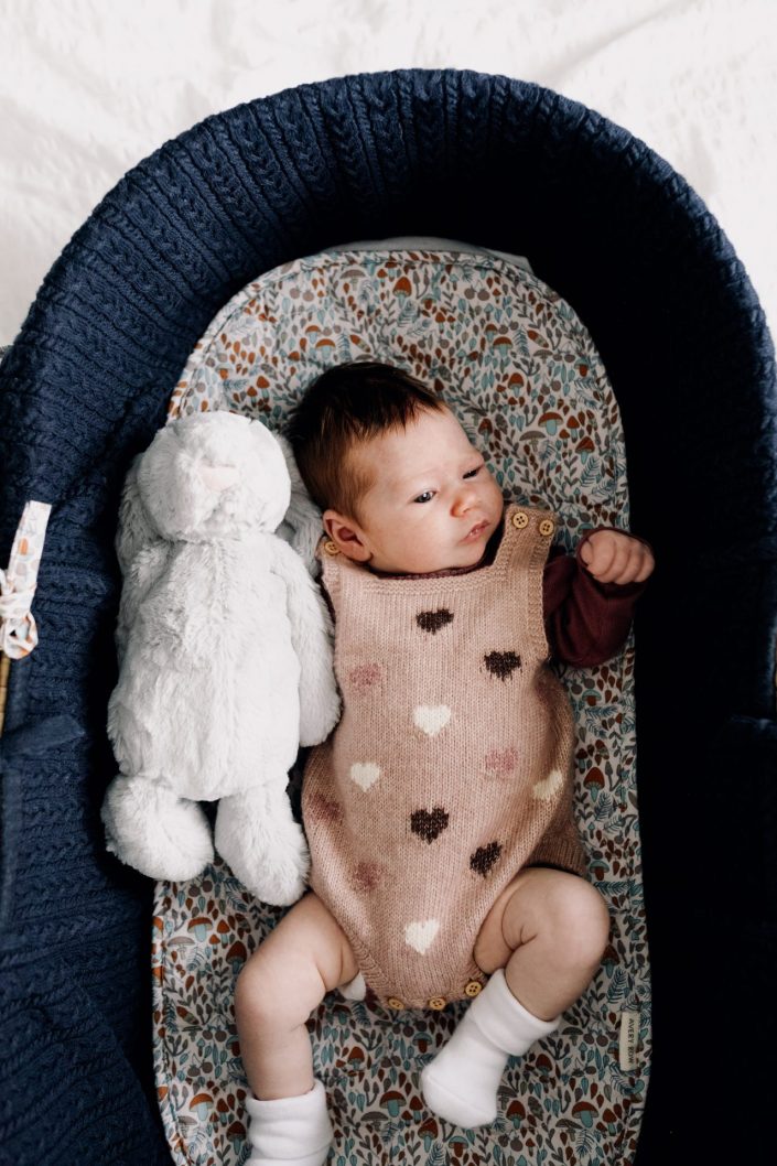 newborn baby girl is laying in the crib and looking. newborn photo shoot at home. Hampshire photo session. Ewa Jones Photography