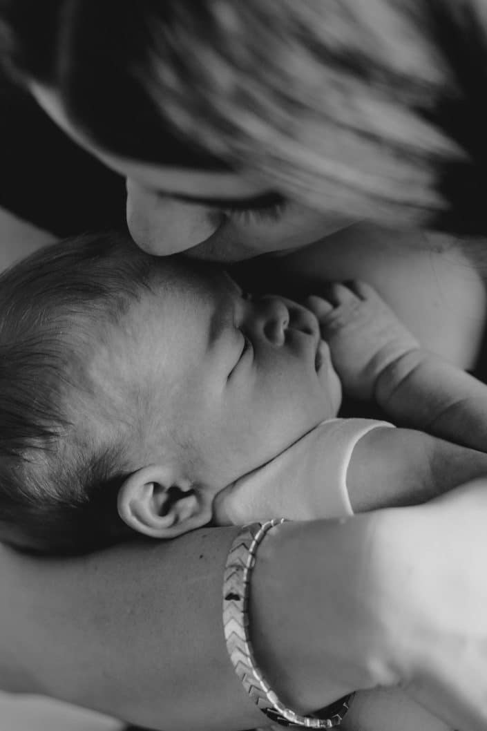 close up image of mum kissing newborn baby. Hampshire newborn photographer. Newborn photo session at home. Basingstoke photographer. Ewa Jones Photography