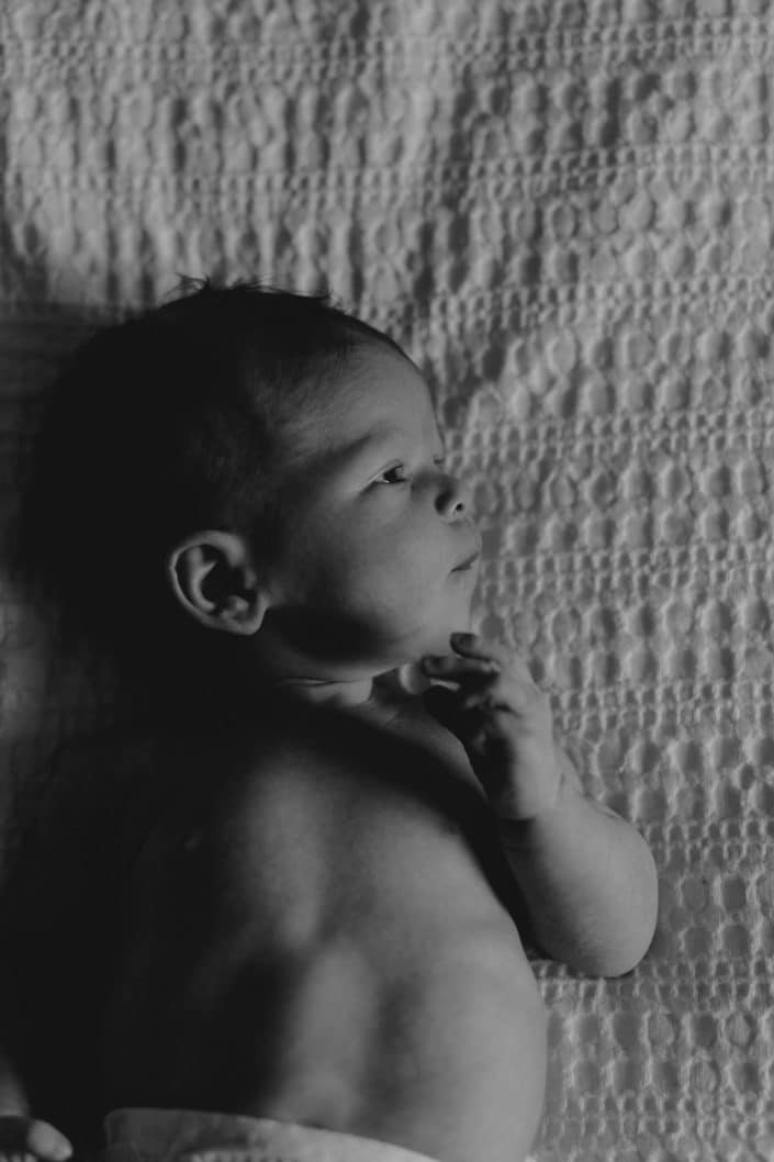 newborn baby girl is laying on the bed. newborn natural photo sessions at home. newborn photoshoot in Hampshire. Ewa Jones Photography