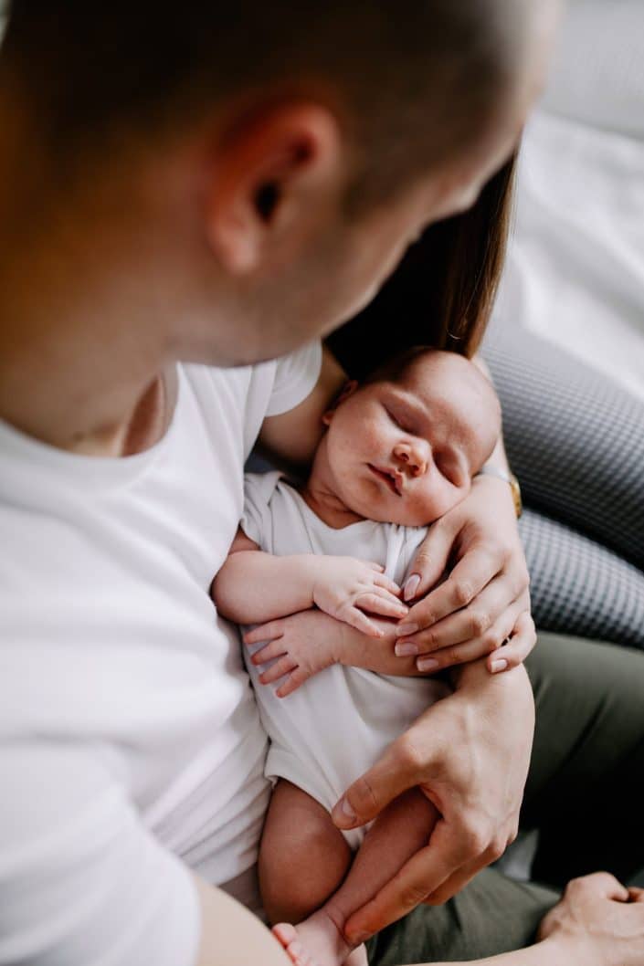 mum and dad are cuddling their newborn baby boy. Newborn photo session at home. Basingstoke and Hampshire newborn photo session. Ewa Jones Photography