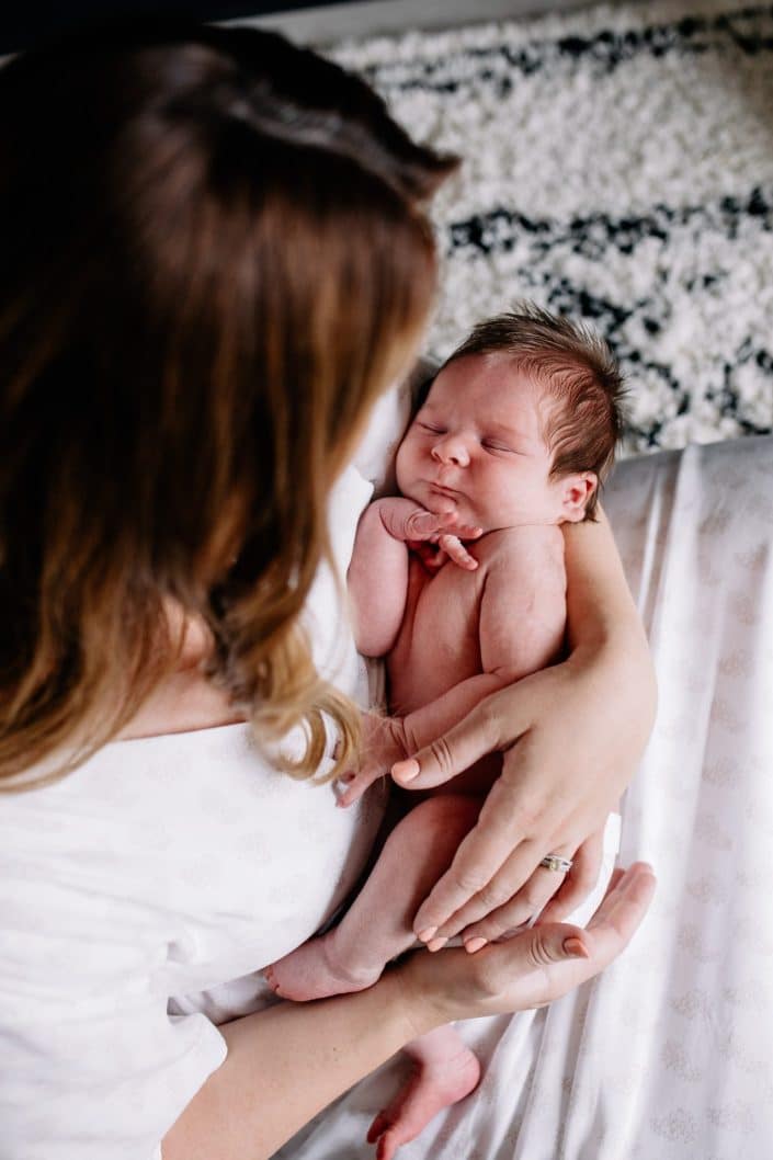 Mum is cuddling baby boy in her arms. newborn photo session at home. Hampshire family photographer. Ewa Jones Photography